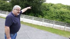 Jos� Manuel Porto, se�alando la maleza que denuncia en el entorno de su casa, en Ferrol.