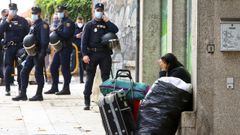 Imagen del desalojo con la polic�a custodiando la entrada ante una okupa con sus maletas