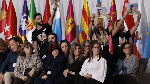 Varios de los familiares de las 237 víctimas de la dana mostrando fotografías de sus familiares