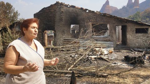 Amavita, vecina de Las Mdulas, junto a los restos de su vivienda, calcinada en el incendio.