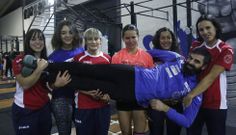 Varias de las integrantes del equipo sostienen a su entrenador, Pablo D�az, en una de sus jornadas de entrenamiento en Oira. 