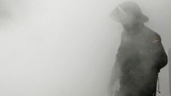 Un polic�a nacional envuelto en el humo provocado por la quema de un contenedor, durante un incidente ocurrido en Pamplona en el 2013