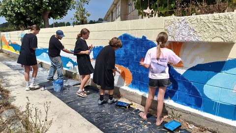 Alumnos del colegio de O Grove CEIP As Bizocas pintan un mural en su entrada dise�ado y bajo la direcci�n de Iago Fontoira.
