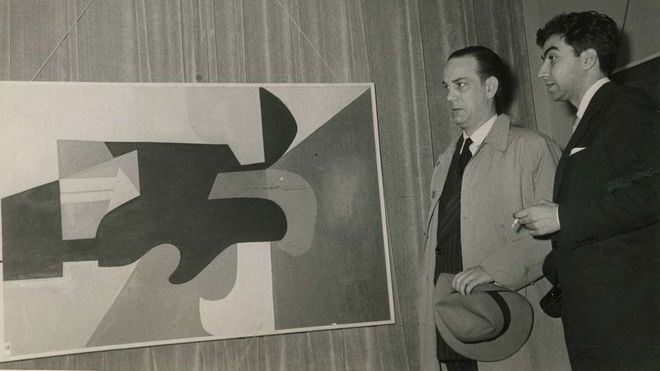 Camilo Jos&eacute; Cela y Antoni T&agrave;pies, en 1953, retratados ante una obra del pintor barcelon&eacute;s expuesta en la galer&iacute;a Biosca, en Madrid.