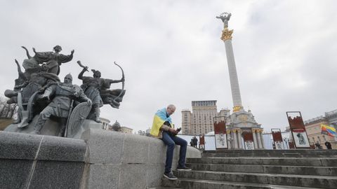Un hombre porta la bandera de Ucrania en la plaza de la independencia de Kiev