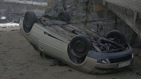 El veh�culo, volcado en la playa Tercera de Luarca