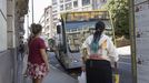 Usuarios del servicio de bus urbano de Santiago esperan en la parada de la plaza de Galicia