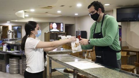 Diana Viéitez, de la cafetería Che de Sigüeiro, entrega unos cafés para llevar a Diego Veiga, de la carnicería Jesus Veiga
