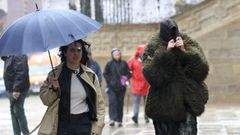 Peatones protegi�ndose de la lluvia en la plaza del Obradoiro de Santiago. 