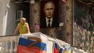Una mujer mira desde un balcn decorado con una bandera de la Armada rusa y un retrato de Putin, el pasado junio en Sebastopol (Crimea).