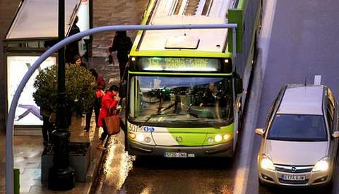 Un autob�s urbano de Vitrasa recoge a un grupo de viajeros en la parada de una c�ntrica calle de Vigo.