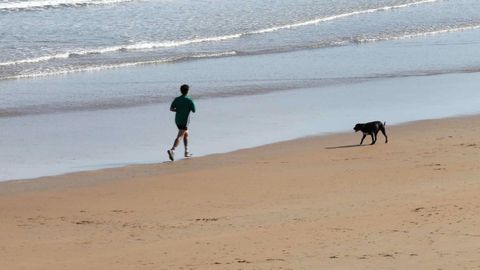 Una persona corriendo por la playa de San Lorenzo de Gijón