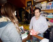 Un comerciante, entregando ayer una rifa a una cliente.