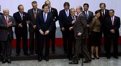 El rey, que lleg� a la foto de familia con retraso y ayud�ndose con una muleta, fue recibido con un aplauso por los dem�s mandatarios.