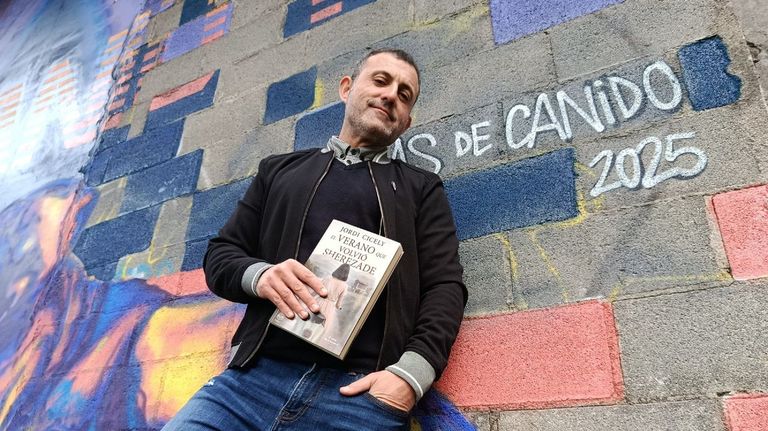 Jordi Cicely posa con su nuevo libro en uno de los murales de las Meninas de Canido, en Ferrol. 