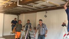 Varios emigrantes, todos de la Costa da Morte, arreglando el local social