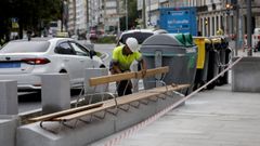 Un operario coloca el respaldo de los bancos de madera del Cant�n Peque�o