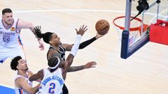 Devin Vassell, de los San Antonio Spurs, lanza ante Shai Gilgeous-Alexander, de los Oklahoma City Thunder, durante el quinto partido de las finales de la Conferencia Oeste de la NBA.