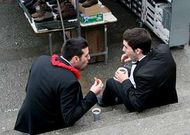 Dos j�venes apuran el chocolate con churros en las escaleras de Santo Domingo.