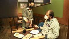 La propietaria del restaurante Los Caracoles de Santiago comprueba el certificado covid de un cliente