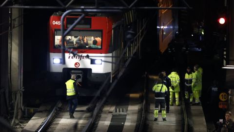Varios operarios junto al tren de Cercan�as que ha descarrilado este martes pasadas las dos y media de la tarde en la entrada de la madrile�a estaci�n de Atocha, lo que ha interrumpido el servicio entre dicha estaci�n y Recoletos, en un momento de fuerte afluencia por el puente de la Constituci�n.