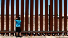 Un ni�o mexicano mira a trav�s del muro que separa a su pa�s de Estados Unidos en Calexico (California)