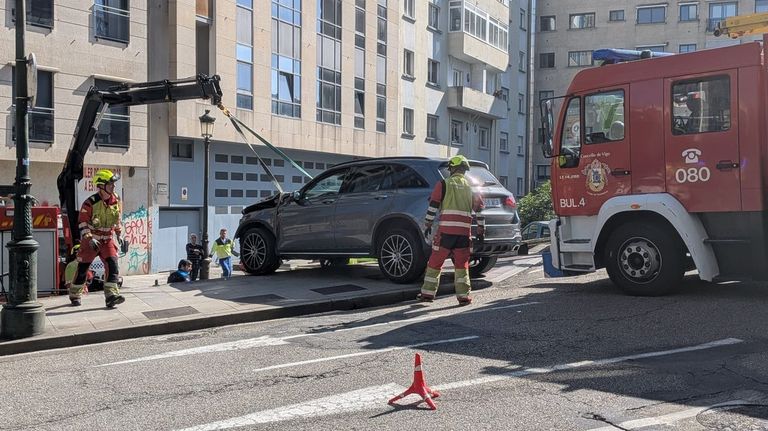 Bomberos retirando el coche siniestrado.