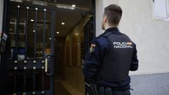Un agente de la Polic�a Nacional en la puerta del piso de Monelos en el que este jueves se produjo una agresi�n con arma blanca