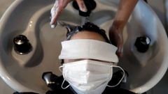 Una mujer acude a la peluquer�a ataviada con mascarilla