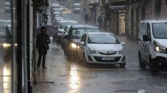 Varios veh�culos, circulando por una calle anegada en Ferrol, en una imagen del viernes pasado.