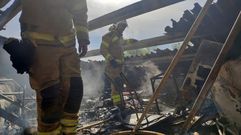 Dos bomberos, en el tejado de la casa que ardi� este martes en Chantada