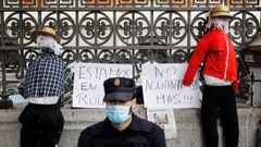 Un agente de Polic�a Nacional frente a dos espantap�jaros colocados junto a dos carteles en los que se leen: �Estamos en la ruina, no aguantamos m�s� colocados durante una manifestaci�n de agricultores en Madrid el pasado 24 de noviembre