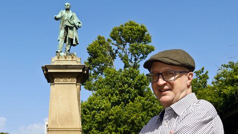 El escritor Félix Caballero posa ante la estatua de Elduayen en los jardines de Montero Ríos.