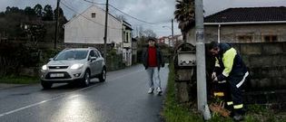 Un operario municipal intenta arreglar una de las farolas situadas junto a la carretera Nacional 555 en Redondela.