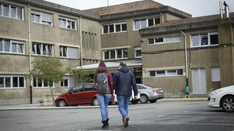 Dos personas se dirigen a la entrada del IES Lamas de Abade, en Santiago