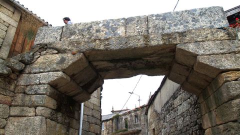 Un arco de bloques de pedra atravesa a vía principal de San Mamede