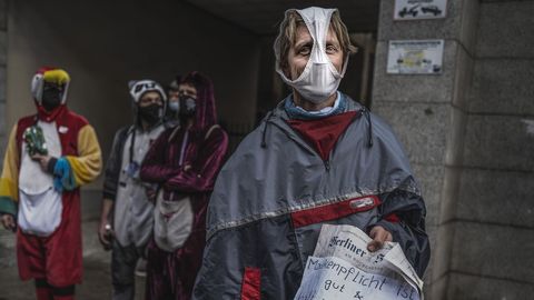 Un hombre en una protesta en Berl�n contra las restricciones, con una braga a modo de mascarilla y un cartel sobre la protecci�n.