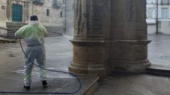 Un operario limpiando las pintadas en una de las columnas de entrada de la Catedral de Lugo