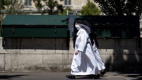 Dos monjas pasean por Pars ataviadas con mascarillas