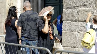 Una turista se abanica por el calor.