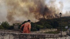 Un vecino de O&iacute;mbra, viendo el humo y las llamas del incendio el d&iacute;a que se origin&oacute;, el 12 de agosto.