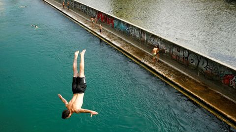 Un joven salta al agua desde un puente en Zurich