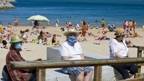 Personas con mascarilla en la playa de Oza. Imagen de archivo