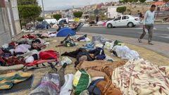 Migrantes durmiendo este domingo en las calles ceut�es, a la espera de acceder al campamento temporal de Loma Colmenar.
