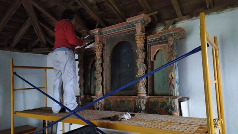 La restauradora Teresa Lpez trabajando en el retablo que se conserva en el interior de la capilla