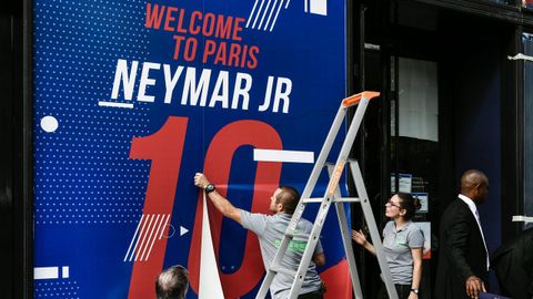 Empleados de la tienda del club colocan un cartel de bienvenida para la estrella brasile�a