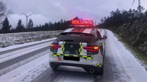 Patrulla de la Guardia Civil en la AC-101, a la altura de O Caxado, advirtiendo del riesgo en la calzada por nieve.