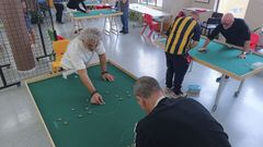 Aficionados de la generaci�n del �Baby Bum� jugando a las chapas en un centro vecinal.