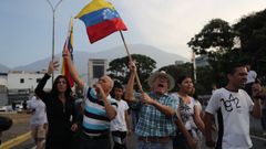 Simpatizantes del presidente interino Juan Guaid� ondean banderas este martes en la base militar La Carlota, donde se encuentra el presidente interino Guaid� y un grupo de militares que le apoyan.