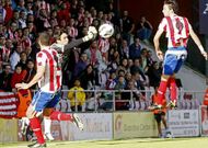 El portero del Mirand�s, despejando de pu�os ante Fran P�rez y �scar D�az.